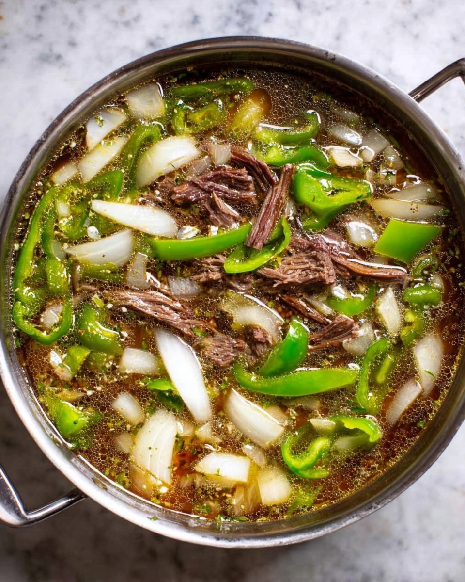 A stainless steel pan filled with a clear broth containing chunks of dark brown shredded meat, large pieces of bright white onion, and vibrant green bell pepper slices scattered evenly across the surface; the broth is lightly seasoned with small floating herbs and spices, all set on a white marbled surface photo taken with an iphone --ar 4:5 --v 7