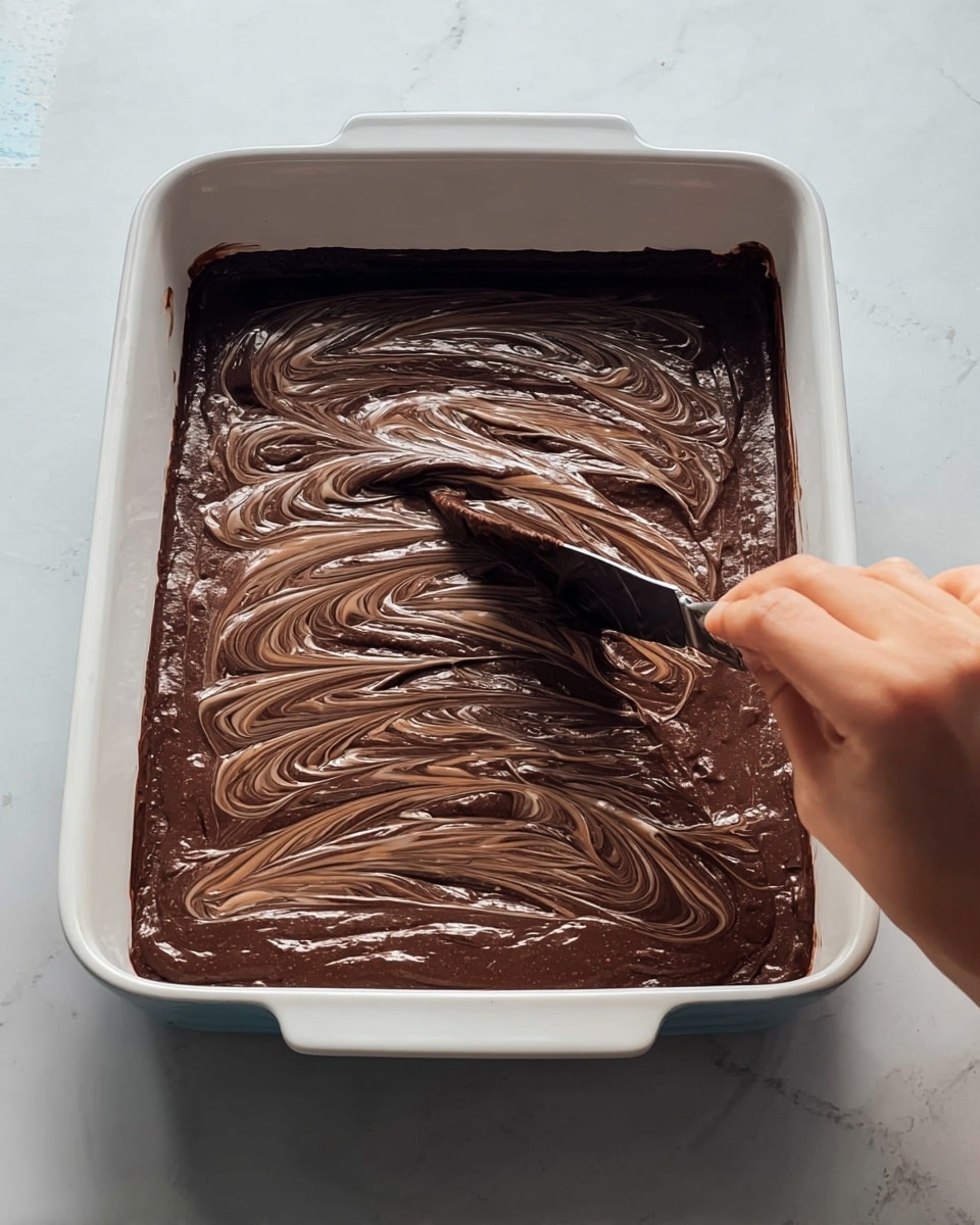 The image shows a white scalloped bowl filled with a dessert consisting of three layers: the bottom layer is a mix of cooked red cranberries and diced apples, glistening and juicy; the middle layer is a thick golden-brown crumbly topping with a rough texture; the top layer is a scoop of smooth, creamy white ice cream melting slightly over the crumbly topping. The bowl sits on a white marbled surface next to a striped cloth napkin and a wooden cutting board. On the cutting board, there are two whole apples with red and yellow skin, a small white bowl filled with fresh cranberries, and star anise and cinnamon sticks scattered around. A silver spoon rests inside the bowl. Photo taken with an iphone --ar 4:5 --v 7
