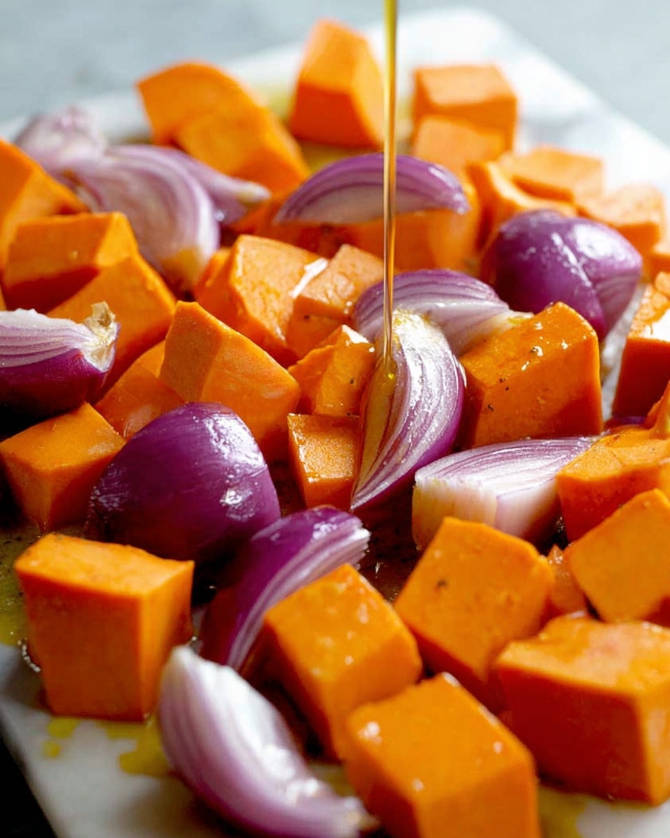 This image shows a close-up view of large orange sweet potato cubes and purple-red onion wedges mixed together, placed on a white marbled surface. The sweet potato cubes are smooth and shiny, with about two layers of visible size, while the onion wedges reveal clear purple layers with white edges. A golden liquid, likely olive oil, is being poured over the vegetables, adding a glossy texture and slight shine to the pieces. The whole scene is bright and colorful, emphasizing the vibrant orange and purple tones. Photo taken with an iphone --ar 4:5 --v 7