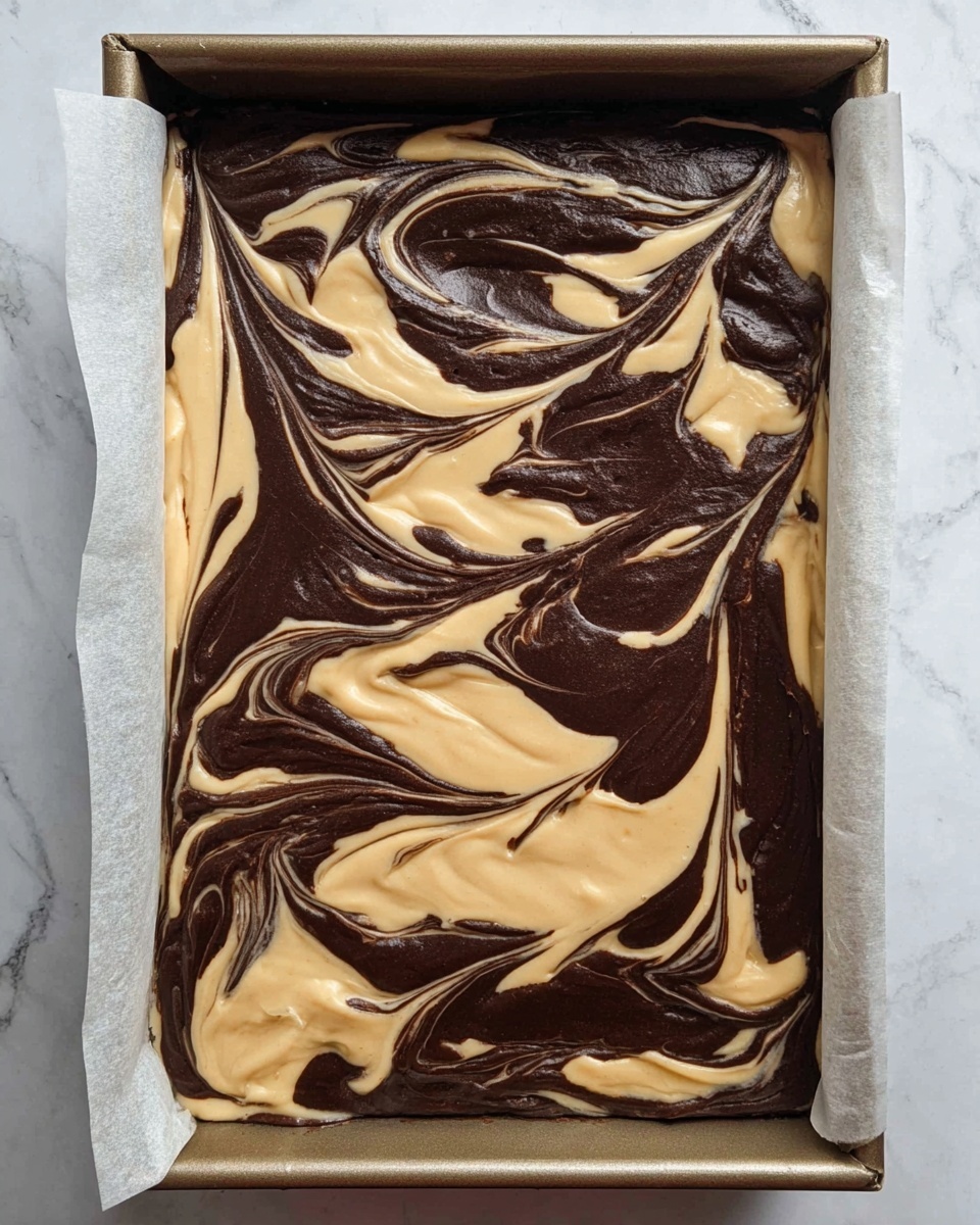 A baking tray filled with a dessert batter showing two main layers swirled together on top: a creamy light beige layer and a deep dark brown layer. The layers form a marbled pattern with smooth swirls and curves mixing the two colors evenly across the surface. The tray is lined with parchment paper, and the batter looks dense and thick, about one even layer deep, with the beige and brown colors blending in artistic waves. The background is a white marbled texture. photo taken with an iphone --ar 4:5 --v 7