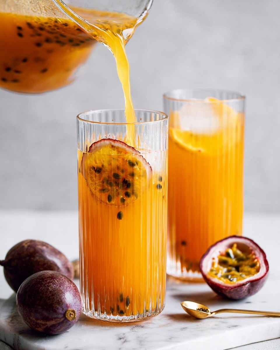 A clear glass measuring cup filled with amber-colored liquid, with a tea bag inside. A woman's hand holds a small black measuring scoop, pouring white granulated sugar into the liquid, with some sugar mid-air falling into the cup. Next to the cup on a white marbled surface, two passion fruits are placed, one whole and one cut open showing its yellow pulp and black seeds. The scene is bright and clean with a soft light. Photo taken with an iphone --ar 4:5 --v 7