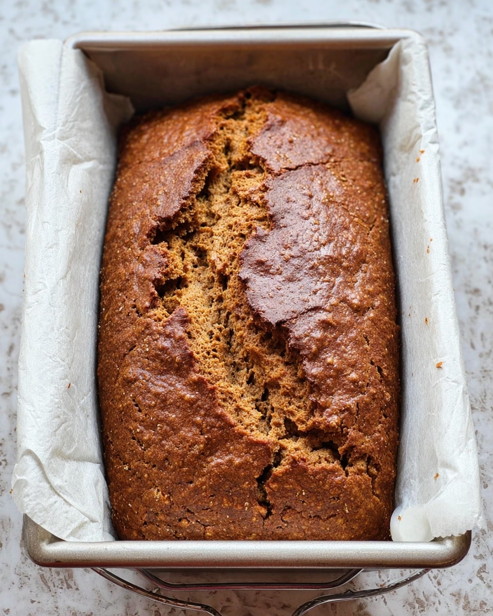 Inside a clear measuring cup, there is a thick orange-brown paste with a smooth but slightly uneven texture, spread in one main layer that clings to the sides of the cup. The paste has some glossy parts and looks rich and sticky. Around the cup, there are small bits of the same paste on a white marbled surface. In the background, partially visible, are a few whole brown eggs adding soft round shapes to the composition. The light is natural, making the colors warm and the texture clear. photo taken with an iphone --ar 4:5 --v 7