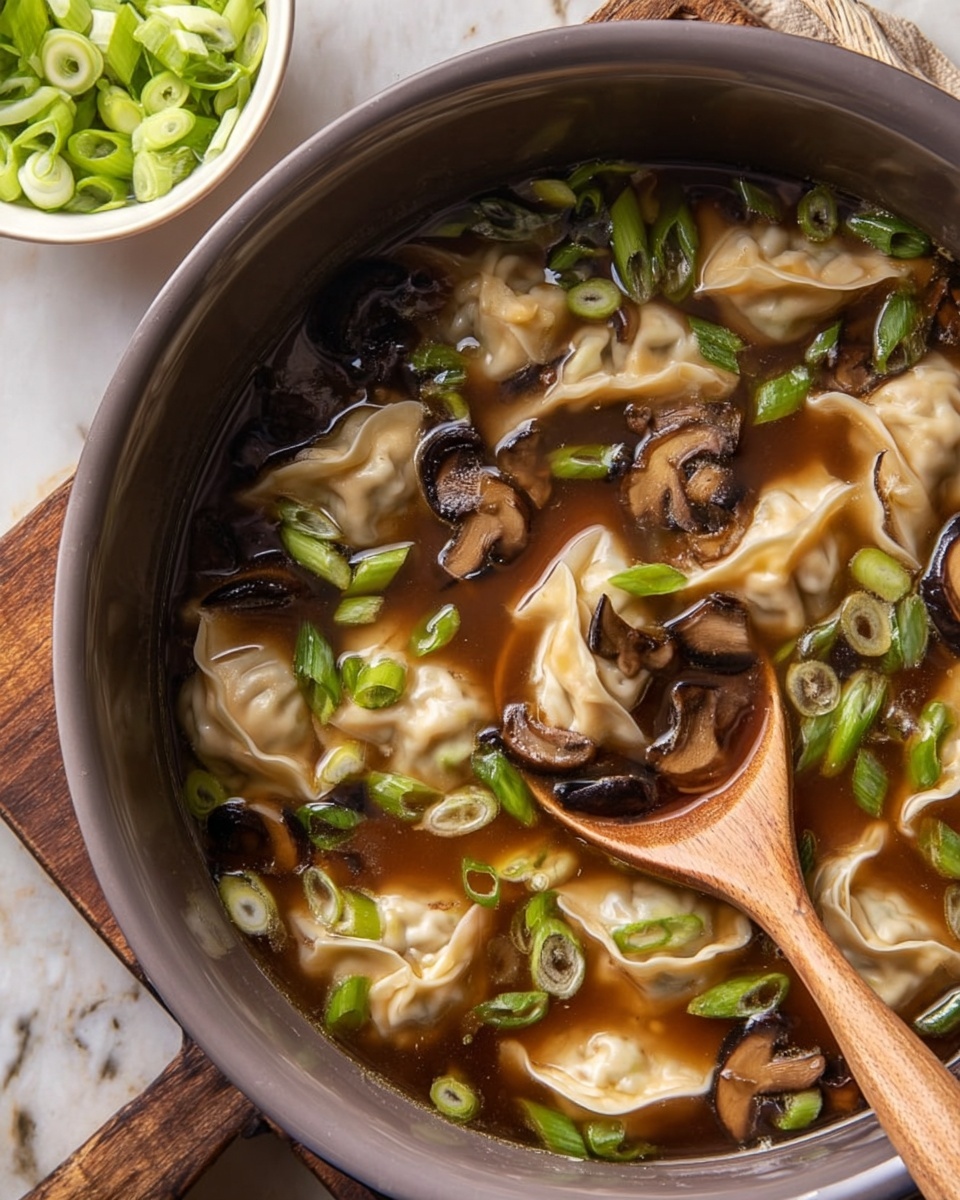 A beige bowl filled with clear broth soup containing six light-colored dumplings with soft, wrinkled edges floating on top; dark brown slices of mushrooms are scattered throughout along with bright green sliced scallions. Red chili oil dots with chili flakes float on the surface, adding contrast and texture. A silver spoon is partially submerged in the right side of the bowl. The bowl sits on a dark wooden surface with small white dishes containing sliced scallions and coarse salt nearby. photo taken with an iphone --ar 4:5 --v 7