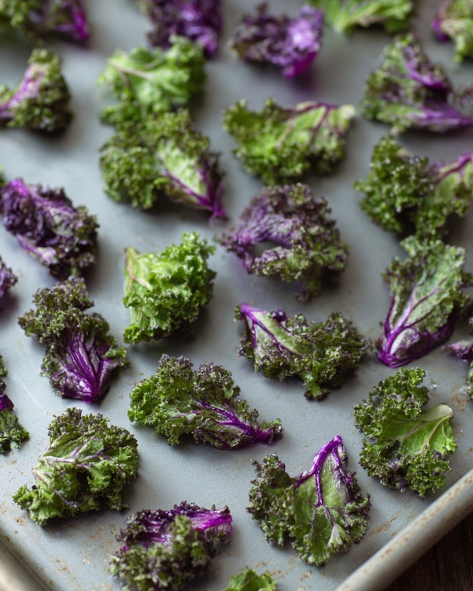 Small pieces of purple and green kale are spread out evenly on a silver baking sheet. The kale pieces have curly, textured leaves with a mix of deep green and purple colors. Each piece is separated well from the others, and the baking sheet sits on a flat surface. The lighting is soft, highlighting the natural shine and freshness of the kale leaves. photo taken with an iphone --ar 4:5 --v 7