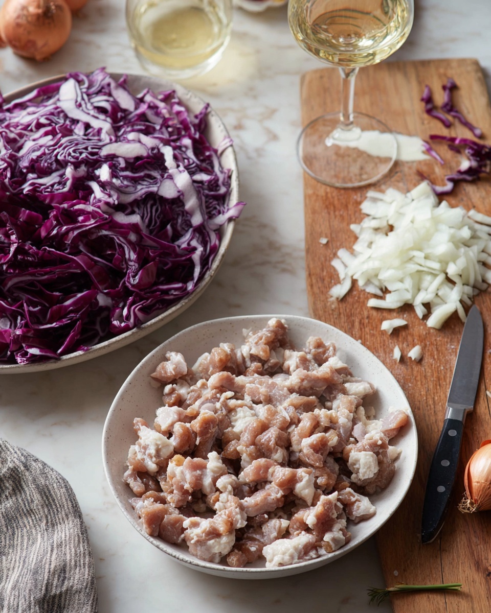 The image shows a table with three main food items arranged on a white marbled surface. At the front, there is a white bowl filled with irregular chunks of light brown raw meat with some visible texture. Behind it to the left, a white bowl is filled with finely shredded layers of deep purple and white radicchio, creating a mix of dark and light colors. To the right, there is a wooden cutting board with finely chopped white onions in the center, a small black knife resting on the board's edge, and a few onion skins scattered nearby. In the background, a glass of light yellow wine sits on the table, adding a slight shine to the scene. Photo taken with an iphone --ar 4:5 --v 7
