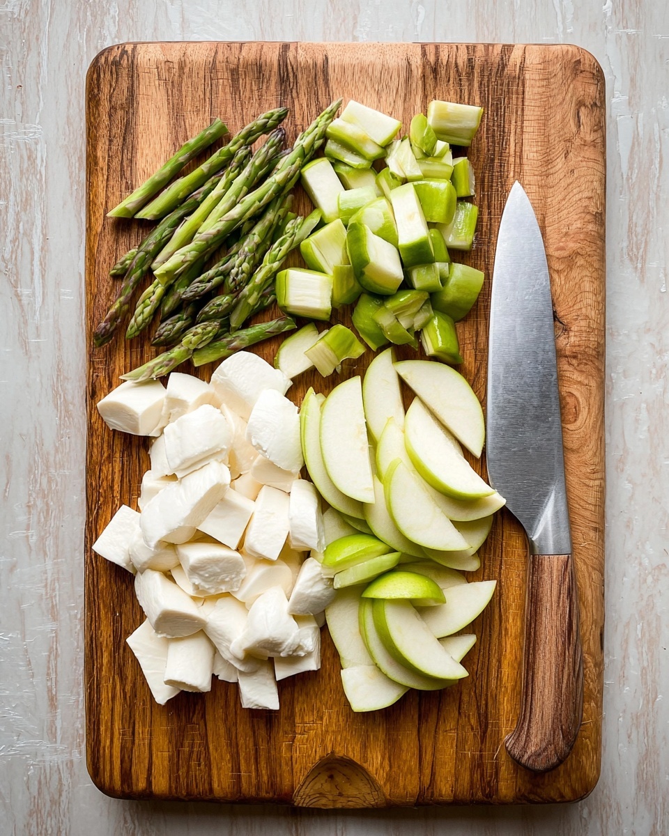 The image shows a flat, unevenly shaped dough base spread with a green pesto sauce that covers the edges and some parts of the center. On top, there are thin slices of white mozzarella cheese scattered evenly across. Mixed in with the cheese are pieces of green asparagus spears, thin slices of green apple, and small bits of leafy greens, creating a fresh, layered look with white and green colors. The dough rests on a white tray, all set against a white marbled surface. Photo taken with an iphone --ar 4:5 --v 7