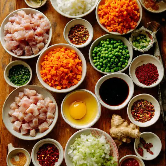 A close top view of many white bowls arranged on a wooden surface, each bowl filled with different colorful ingredients: diced pink raw chicken, chopped orange carrots, chopped white onions, green peas, chopped light green spring onions, minced ginger and garlic, a bowl with a yellow beaten egg, dark soy and hoisin sauces, bright red chili flakes, and a few other sauces and spices in small white bowls. The bowls create a vibrant mosaic of colors and textures, displaying the fresh and raw components before cooking. Photo taken with an iphone --ar 4:5 --v 7