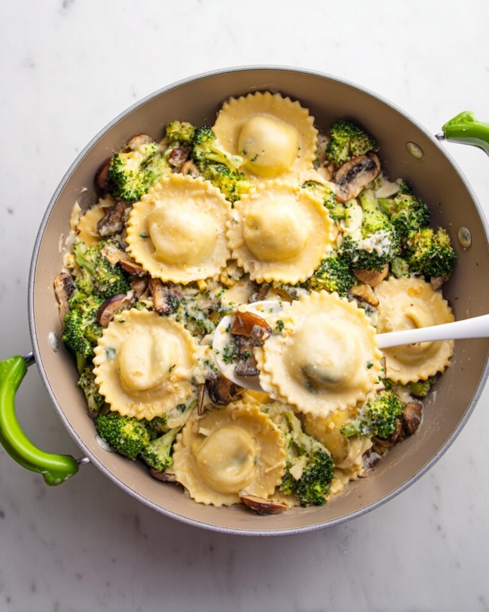 The image shows a grey pan with green handles filled with large round ravioli pieces in a creamy beige sauce. The sauce is thick and mixed with small green broccoli florets, light brown onion slices, and chopped walnut pieces. A white spoon with a marble pattern rests inside the pan, partly lifting a ravioli. The pan sits on a white marbled surface. The colors are soft with the light yellow ravioli, green broccoli, and the creamy sauce creating a rich, comforting look. photo taken with an iphone --ar 4:5 --v 7