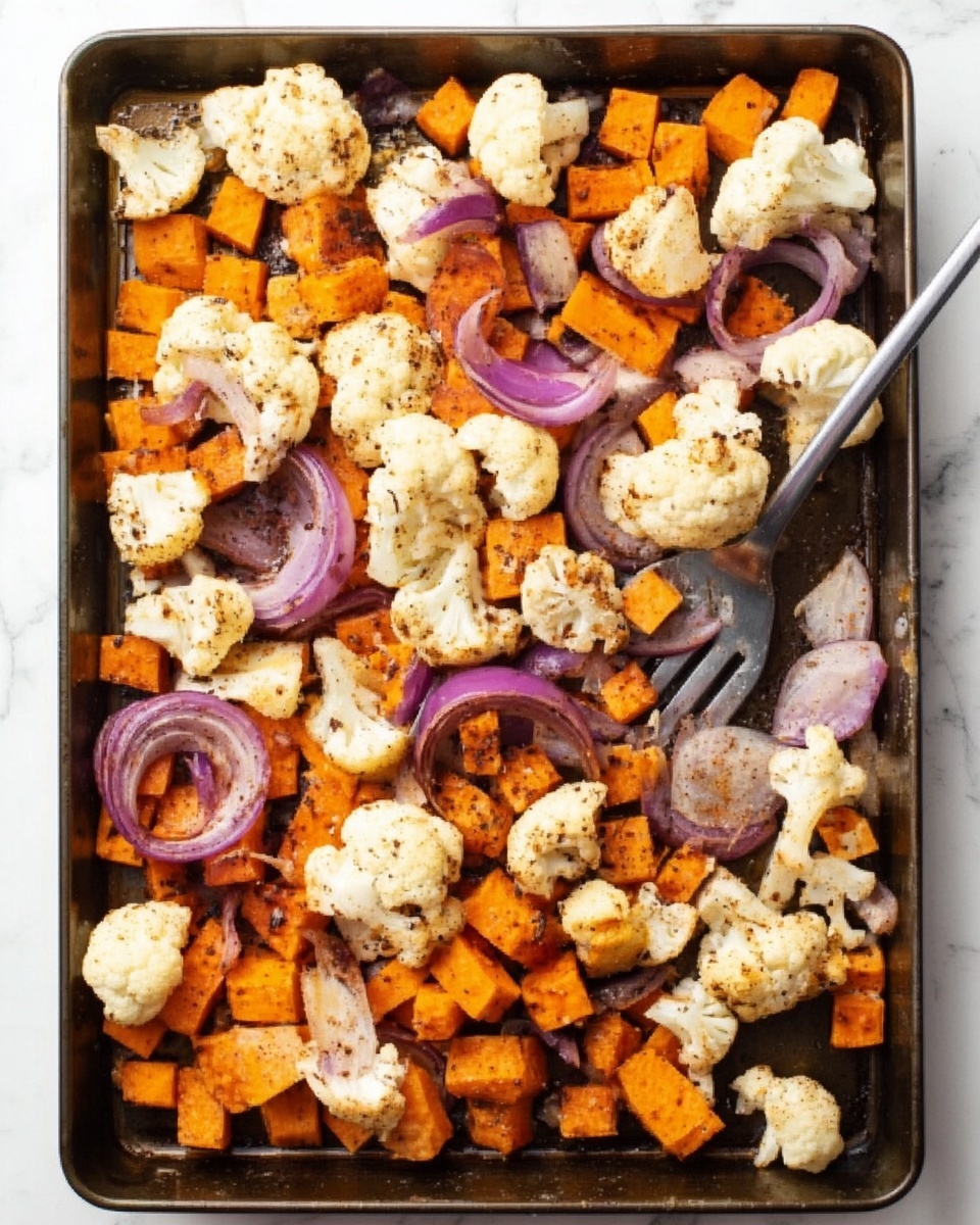 This image shows a metal tray filled with a mix of roasted vegetables on a white marbled surface. The tray holds three main layers: the largest layer consists of white cauliflower florets scattered across the tray, the second layer is made up of small, cubed bright orange pieces of sweet potato, and the third layer features rings and slices of purple-red onions spread evenly on top. There is a silver spatula resting inside the tray slightly towards the center-left among the vegetables. The vegetables appear roasted with a light coating of seasoning giving some brown spots. photo taken with an iphone --ar 4:5 --v 7