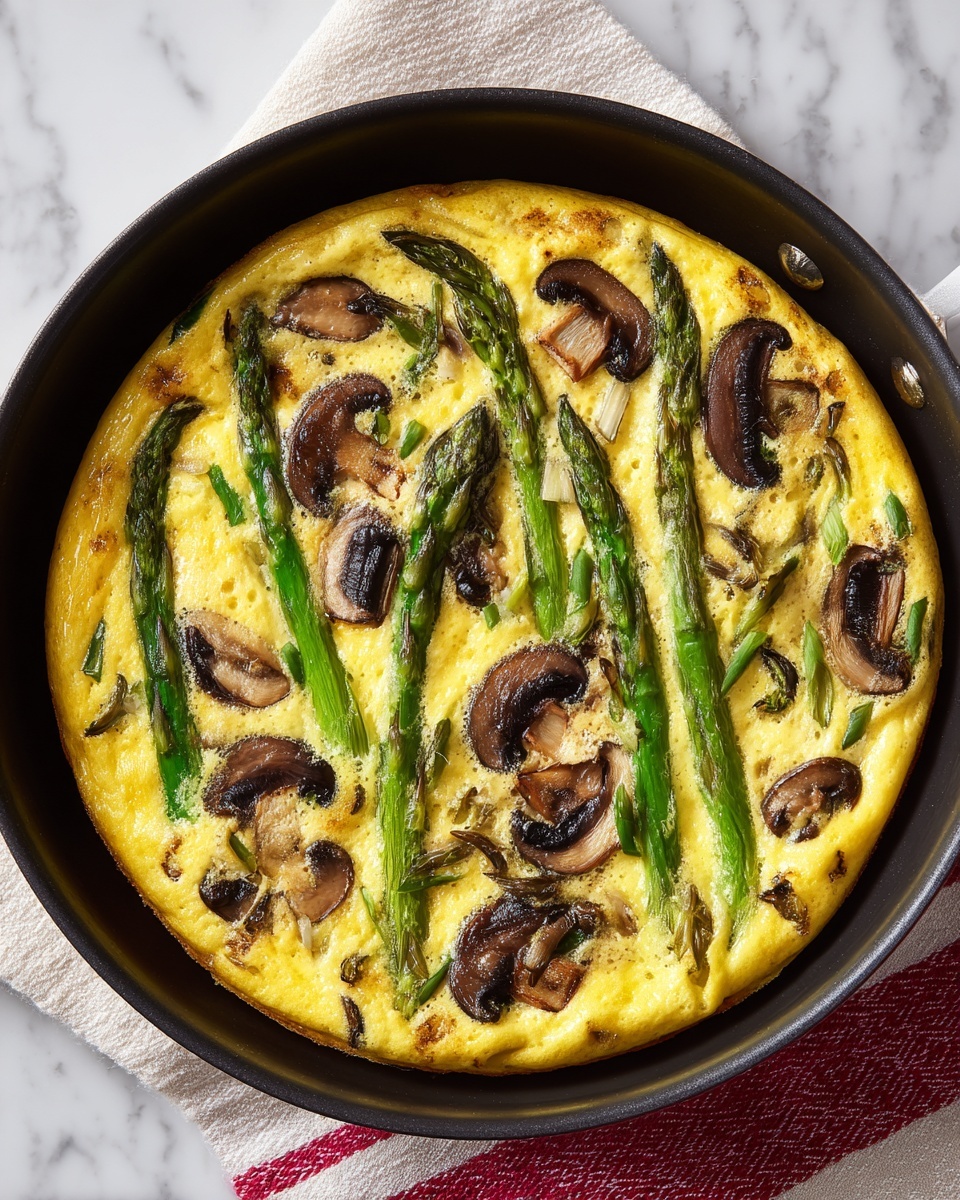A white plate holds a round frittata that is cut into six triangular pieces. The frittata has a thick, golden-yellow egg base with a slightly browned edge. On top, there are green asparagus pieces arranged unevenly, with some tips and stalks visible. Scattered sliced brown mushrooms add texture and contrast. Small white crumbles of cheese are spread over the surface, along with thinly sliced green onions that add a fresh touch. The plate rests on a white marbled surface. photo taken with an iphone --ar 4:5 --v 7