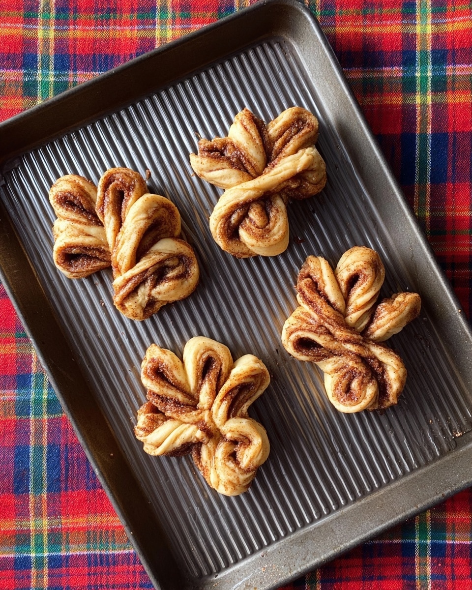 Five twisted, golden brown cinnamon pastries sit on a round white plate with a wood grain stripe on one side. Each pastry has multiple layers rolled and folded, showing dark brown cinnamon swirls inside. The pastries have a slightly crisp texture with some darker toasted spots. The plate is placed on a colorful plaid cloth with red, green, yellow, and blue stripes. photo taken with an iphone --ar 4:5 --v 7