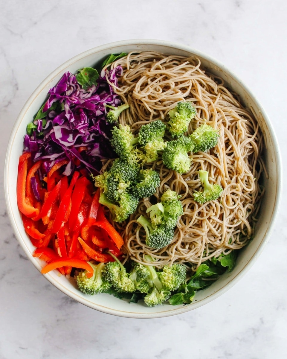 A white oval plate holds four neat piles of vegetables arranged side by side: at the top right, bright green broccoli florets with textured, thick stems; below them are thin, long slices of vibrant red bell pepper; next to the pepper are fine orange carrot sticks, slightly uneven but thin; and the bottom left has roughly chopped purple cabbage with white streaks, showing a crinkled texture. The plate sits on a white marbled surface. photo taken with an iphone --ar 4:5 --v 7