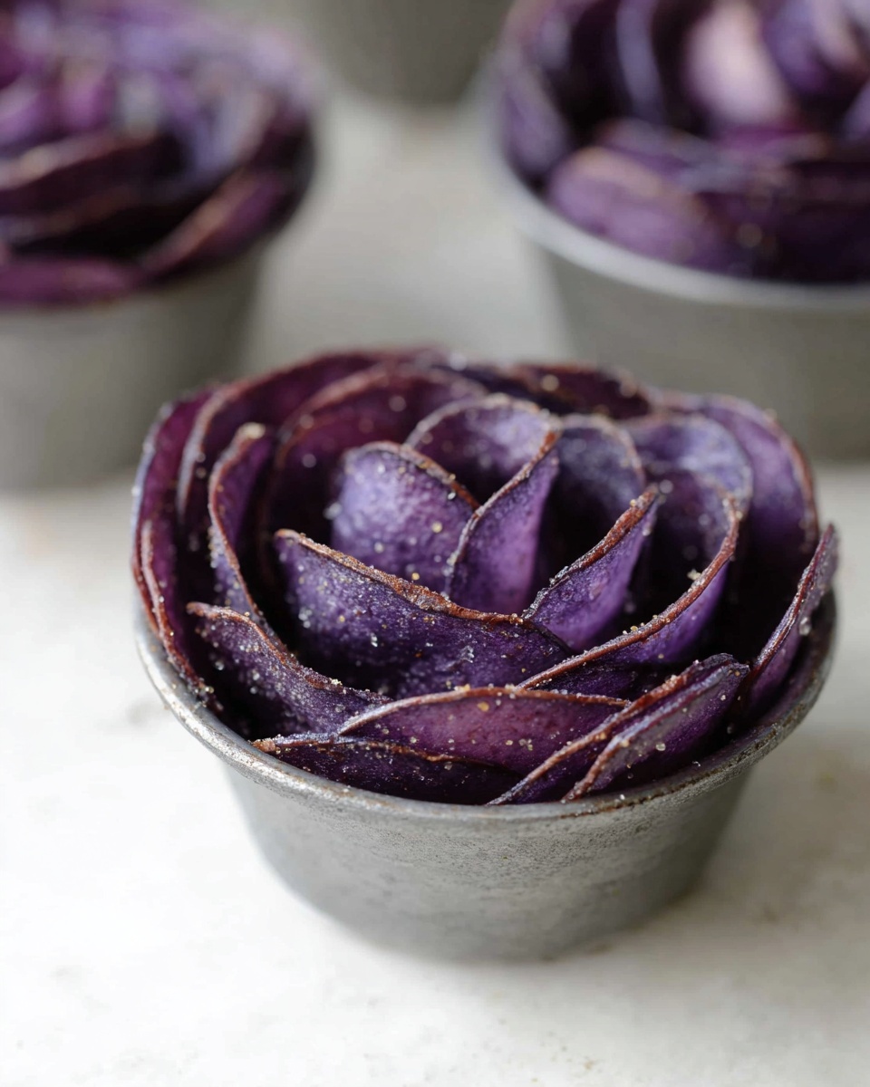 A white colander filled with about twenty small, dark purple potatoes. The potatoes have a rough, natural texture with some faint dirt marks and small patches on their skin. The colander has evenly spaced holes around its side and sits on a white marbled surface. The overall colors are the deep purple of the potatoes against the bright white colander and pale background, creating a clean and fresh look. photo taken with an iphone --ar 4:5 --v 7