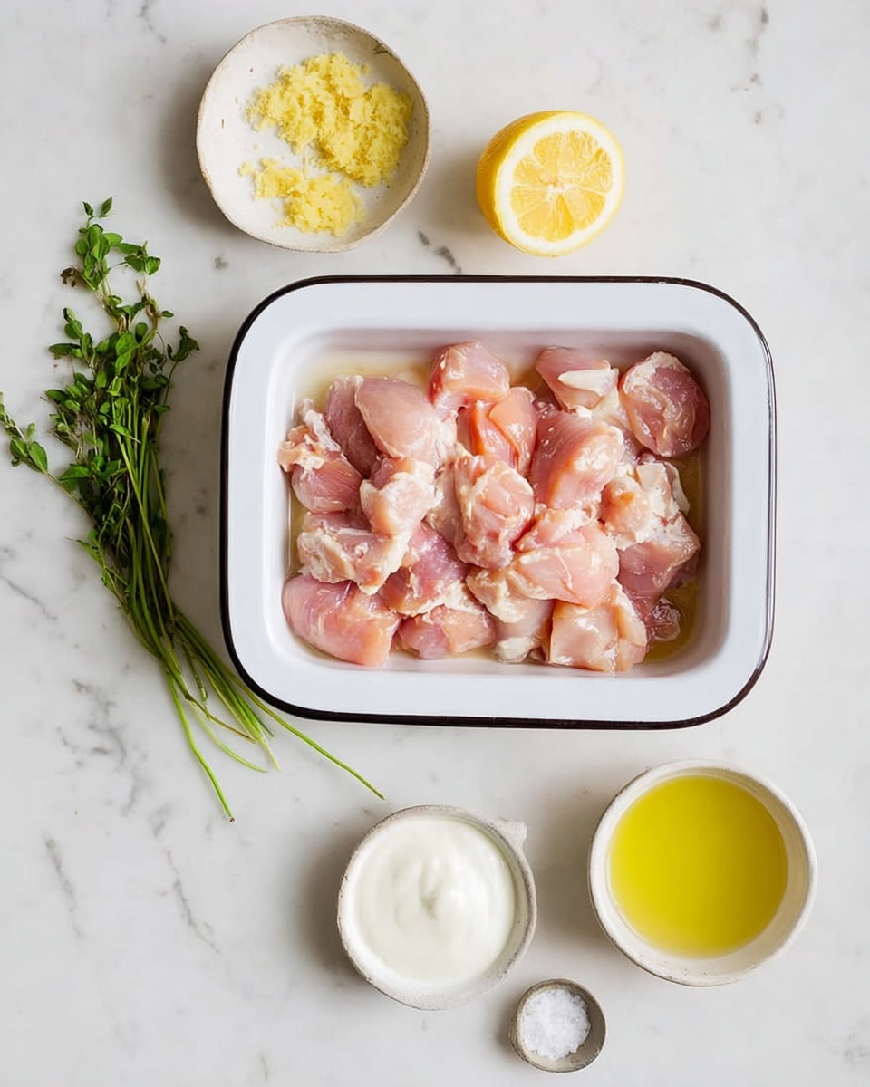 The image shows two white bowls with red rims on a white marbled surface. Each bowl has a layered salad starting with green lettuce at the bottom. On top of the lettuce are grilled chicken skewers with a slightly browned look. One bowl shows a mix of dark purple olives on the left side, diced green cucumber pieces beside them, a scoop of white creamy sauce in the center, and thin slices of red onion on the right side. Colorful halved cherry tomatoes in red, orange, and yellow are placed near the bottom right with a black spoon resting inside the front bowl. To the left of the bowls, there is a glass jar filled with a yellow liquid, likely dressing, and some green leafy stems nearby. A striped cloth napkin appears on the right side of the front bowl. Photo taken with an iphone --ar 4:5 --v 7
