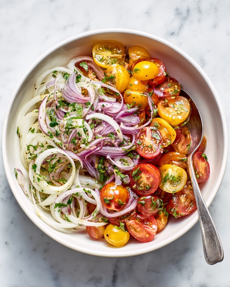 A clear glass bowl holds a colorful salad with three main layers: bright red and yellow cherry tomatoes cut in half, white small rounds of mozzarella cheese, and thin slices of pale purple onion mixed evenly. There are finely chopped green herbs scattered on top with a light coating of dressing giving a slight shine. A silver fork rests inside the bowl on the left side. The bowl sits on a white marbled surface. photo taken with an iphone --ar 4:5 --v 7