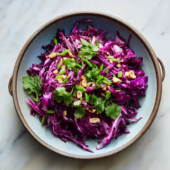 A glass bowl holds six different layers of fresh ingredients arranged side by side in neat sections. On the left, there is a layer of thinly sliced dark purple cabbage with some white parts showing. Next to it is a bright orange layer of finely shredded carrots. To the right of the carrots is a layer of chopped green onions in small rounds. Beside the green onions is a bunch of leafy green cilantro with broad flat leaves. Below the cilantro, there are small chopped pieces of bright green bell pepper, and next to the bell pepper are rough chopped light tan peanuts. All these layers sit on a clean white marbled surface. photo taken with an iphone --ar 4:5 --v 7
