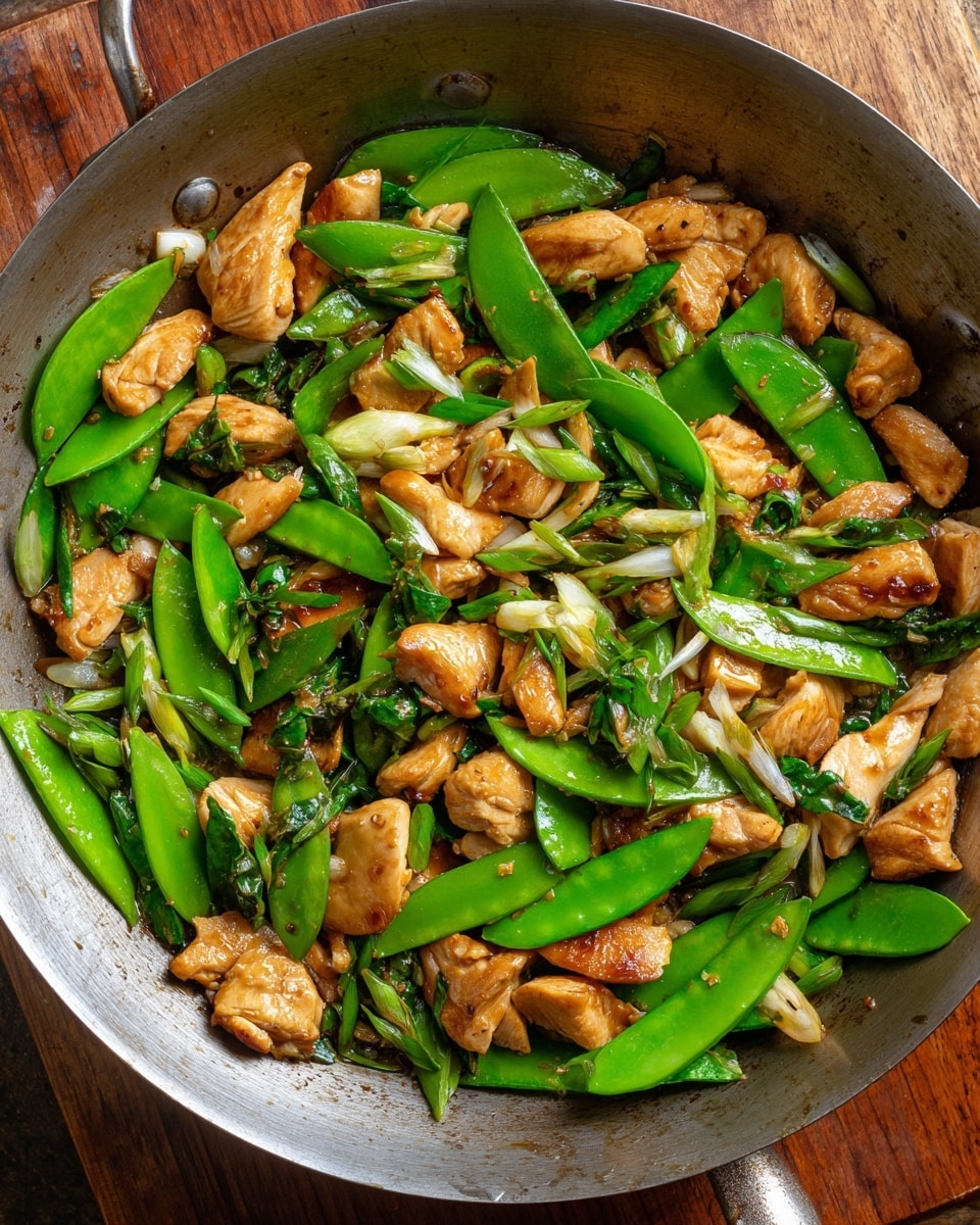 A white bowl filled with a base layer of fluffy white rice, topped with a colorful mix of light brown cooked chicken strips and bright green snow peas and green onion pieces. The chicken pieces have a soft, smooth texture, while the snow peas are crisp and shiny, some showing the inside seeds. The green onions add extra green color and a fresh texture. The bowl sits on a white marbled surface with green onions visible around it. Photo taken with an iphone --ar 4:5 --v 7