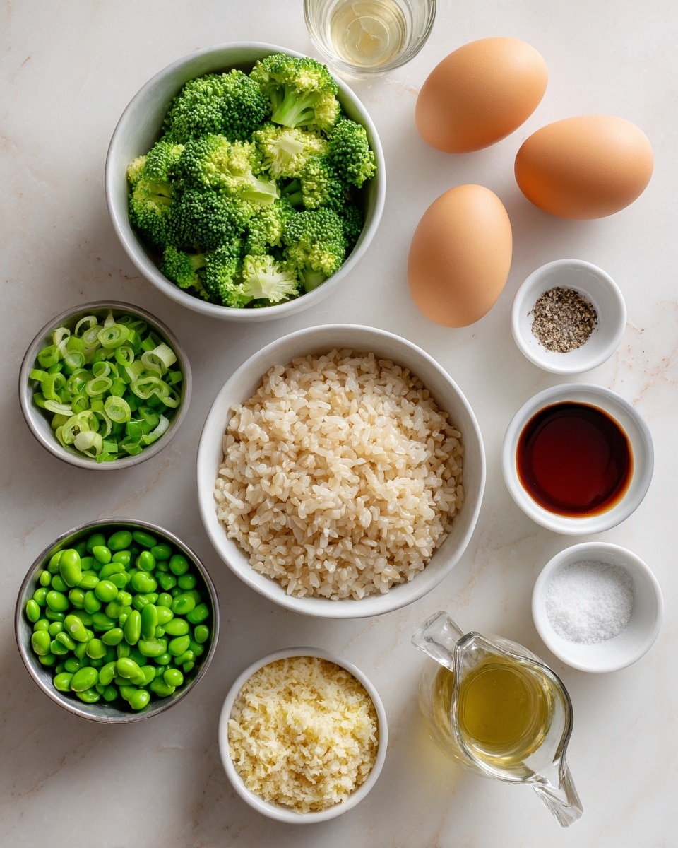 A clean white marbled surface holds several white and silver bowls arranged neatly. There is one white bowl filled with light brown cooked rice in the center. Surrounding it are silver bowls with bright green peas, bright green edamame, and broccoli florets with rich green textures. Another silver bowl contains chopped green onions. Two whole brown eggs rest on the surface close to small white bowls, one holding a mix of yellow and white minced ingredients, another with a pale powder, and a third with salt and ground black pepper. There are also small white and clear glass containers with light golden and dark brown liquids. photo taken with an iphone --ar 4:5 --v 7