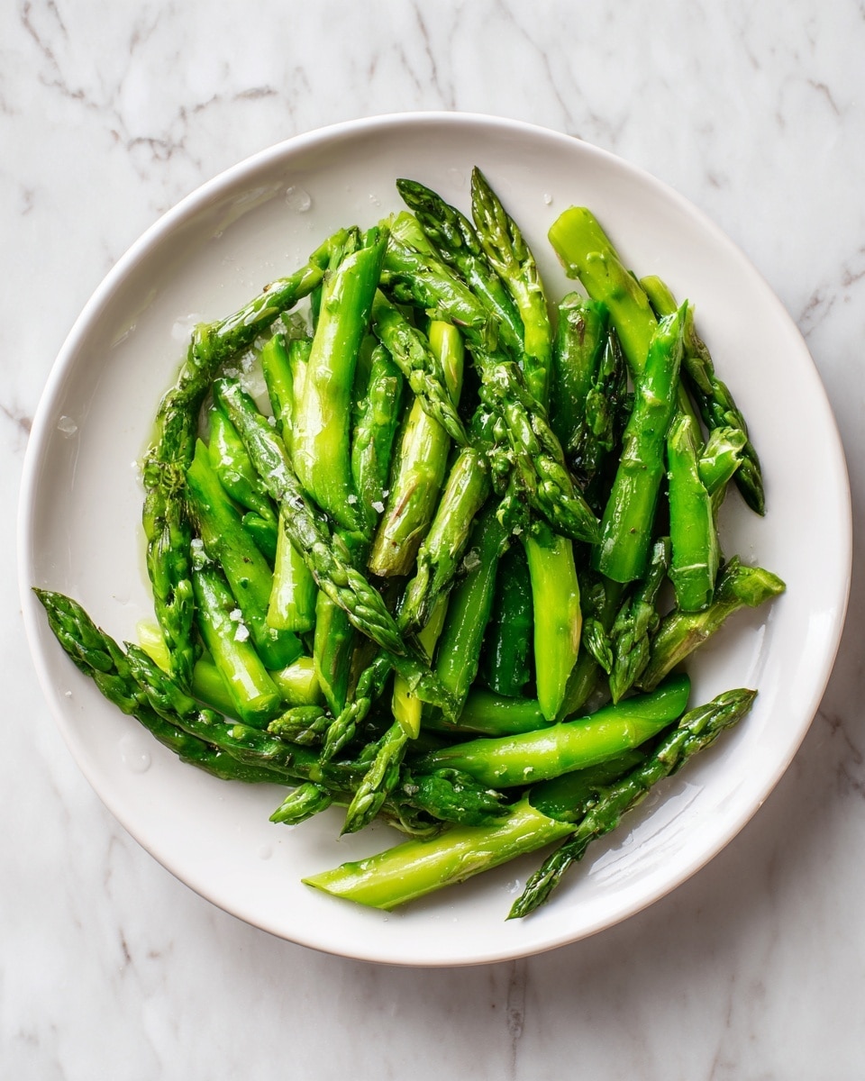 A close-up image of a boiled egg cut in half, showing two clear layers: a smooth, firm white outer layer and a soft, bright orange yolk inside that is slightly runny and shiny. The egg white has a clean, matte texture, while the yolk looks rich and moist with a bit of slight spillover on one side. Tiny black pepper pieces are sprinkled sparingly on the white and yolk, adding small dark spots. The egg halves rest on a white marbled surface with subtle grey lines. The focus is on one half with another egg half partially visible at the edge. photo taken with an iphone --ar 4:5 --v 7