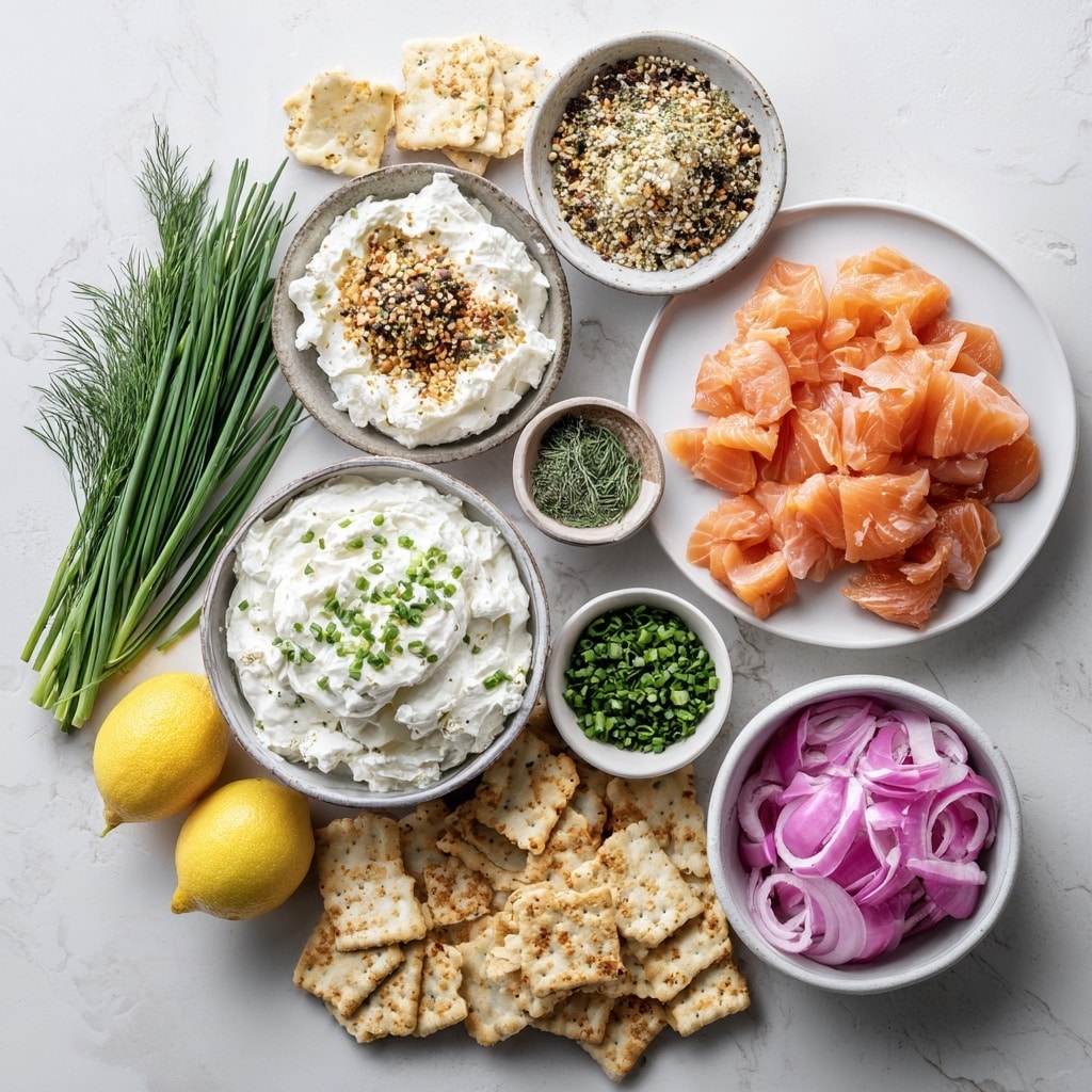 A clear glass bowl contains three visible layers of ingredients. The bottom layer is thick, white cream cheese with a smooth, soft texture. On top of this is a scattered layer of bright orange smoked salmon pieces, thin and slightly curled. The final layer is a sprinkling of finely chopped green chives, evenly distributed over the salmon. The bowl sits on a white marbled surface. photo taken with an iphone --ar 4:5 --v 7