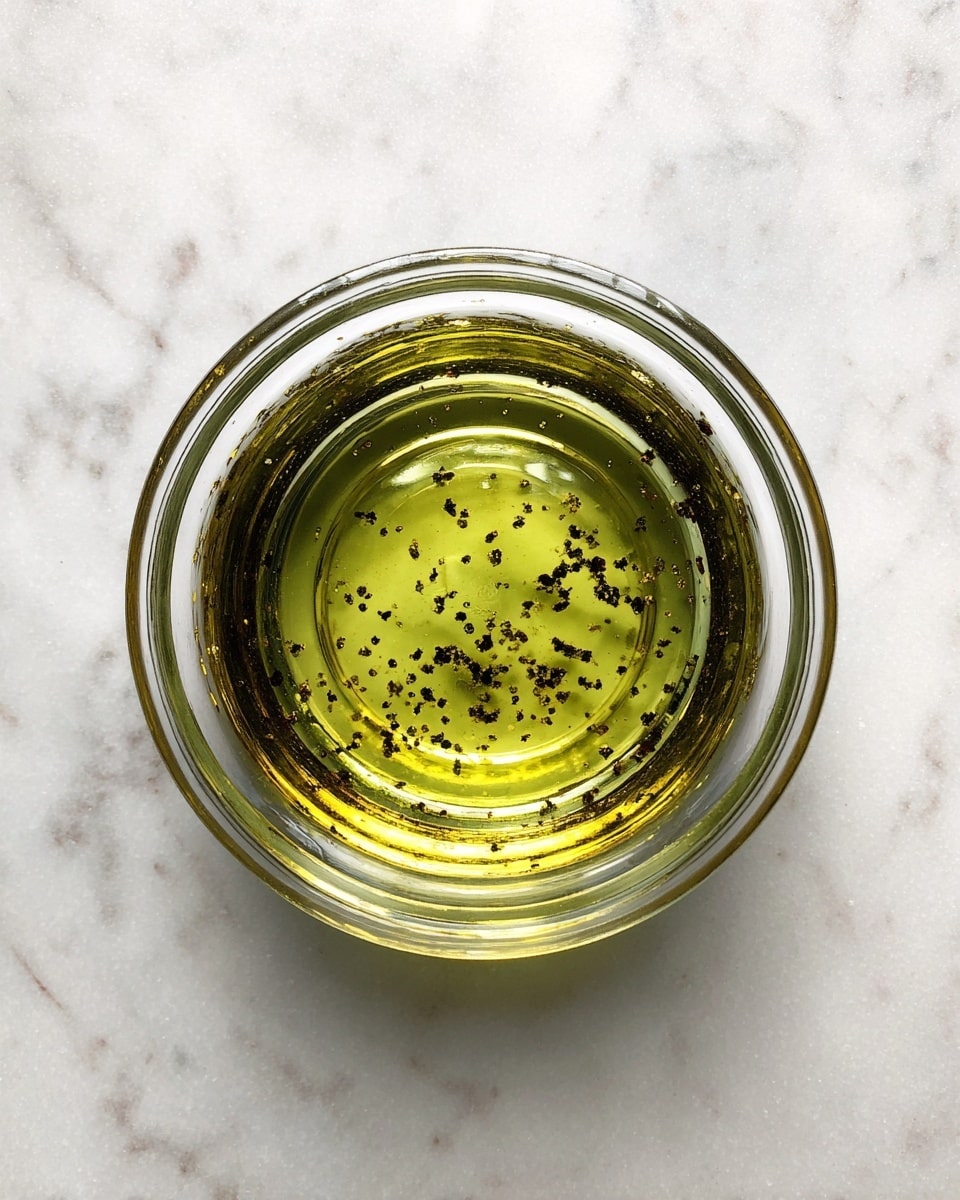 A large white bowl holds a colorful salad featuring three main layers: the base layer of chickpeas and diced red peppers is mixed with finely chopped herbs and small pieces of black olives; the middle layer is made of pale white cauliflower florets, scattered evenly across the salad; on the top, fresh green parsley leaves are placed as garnish, adding a vibrant contrast. Two thin silver spoons rest inside the bowl on the right side. The bowl is set on a white marbled surface. photo taken with an iphone --ar 4:5 --v 7