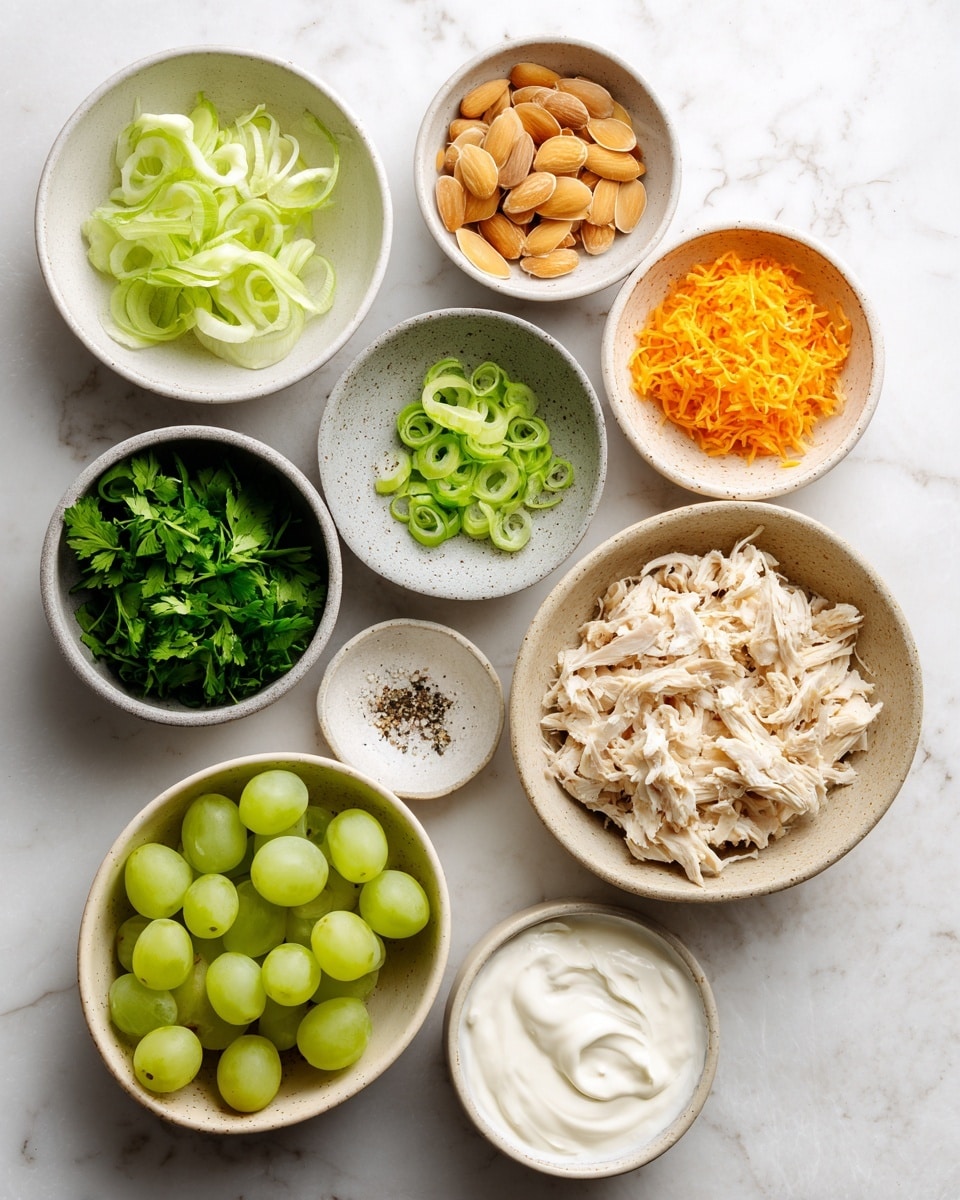 A top-down view of nine small bowls with ingredients arranged on a white marbled surface. The largest bowl at the bottom holds shredded light beige cooked chicken. To its right, a bowl filled with light brown toasted almond slices. Above that, a small white bowl contains bright orange grated zest, possibly orange or carrot. Next to it, a grey bowl with fresh green leafy herbs. On the left side, a white bowl contains sliced pale green celery. Above that, a white bowl filled with chopped green onions. In the center, a speckled beige bowl holds halved green grapes. A small white bowl with a mix of salt and pepper sits between the shredded chicken and grapes. Finally, a small orange bowl contains white creamy mayonnaise and sour cream. Everything is neatly arranged on a clean white marbled surface. Photo taken with an iphone --ar 4:5 --v 7