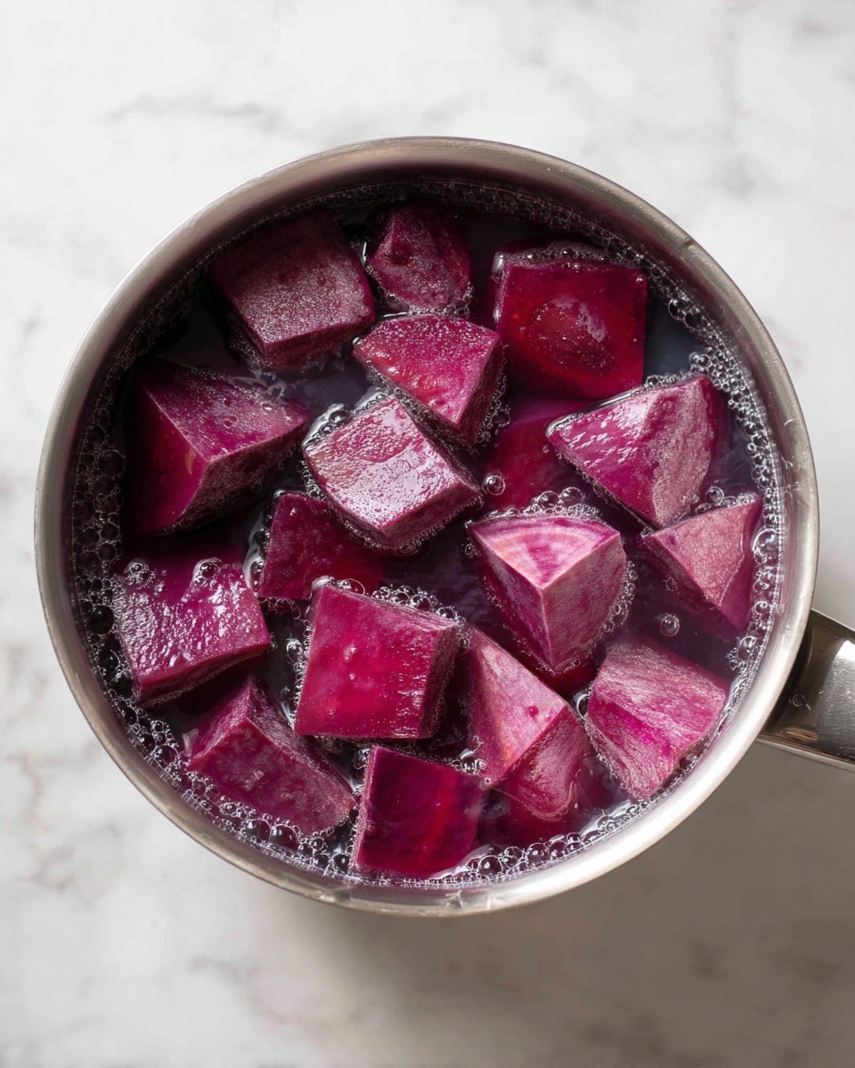 This image shows a silver pot filled with water and many chunks of purple sweet potatoes submerged inside. The sweet potato pieces have a rough, natural texture and are various sizes, mostly cube-shaped with some triangular parts visible. The water has a slightly purple tint, likely from the sweet potatoes, and tiny bubbles are floating on the surface. The pot is sitting on a white marbled surface. photo taken with an iphone --ar 4:5 --v 7