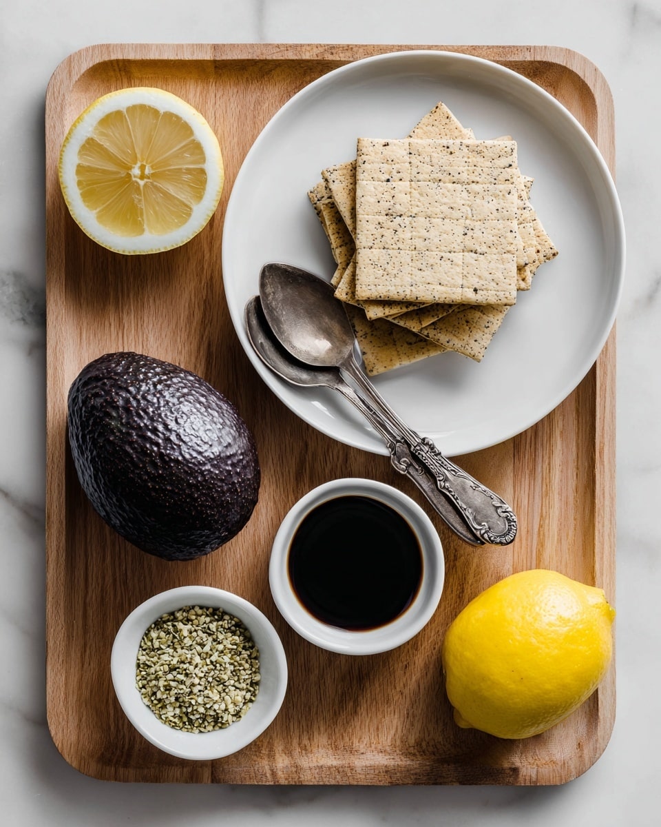 A white plate holds one large dark purple avocado with a rough texture on the left side, accompanied by two vintage-style silver spoons placed on the right of the avocado. Above the white plate, a white bowl is filled with stacked square tan crackers with a slightly speckled surface. To the right of the bowl, a bright yellow whole lemon sits next to a white dish holding dark balsamic vinegar. Below the white dish, a small white bowl contains light green hemp seeds. All items are arranged neatly on a light wooden cutting board, set on a white marbled textured surface. Photo taken with an iphone --ar 4:5 --v 7