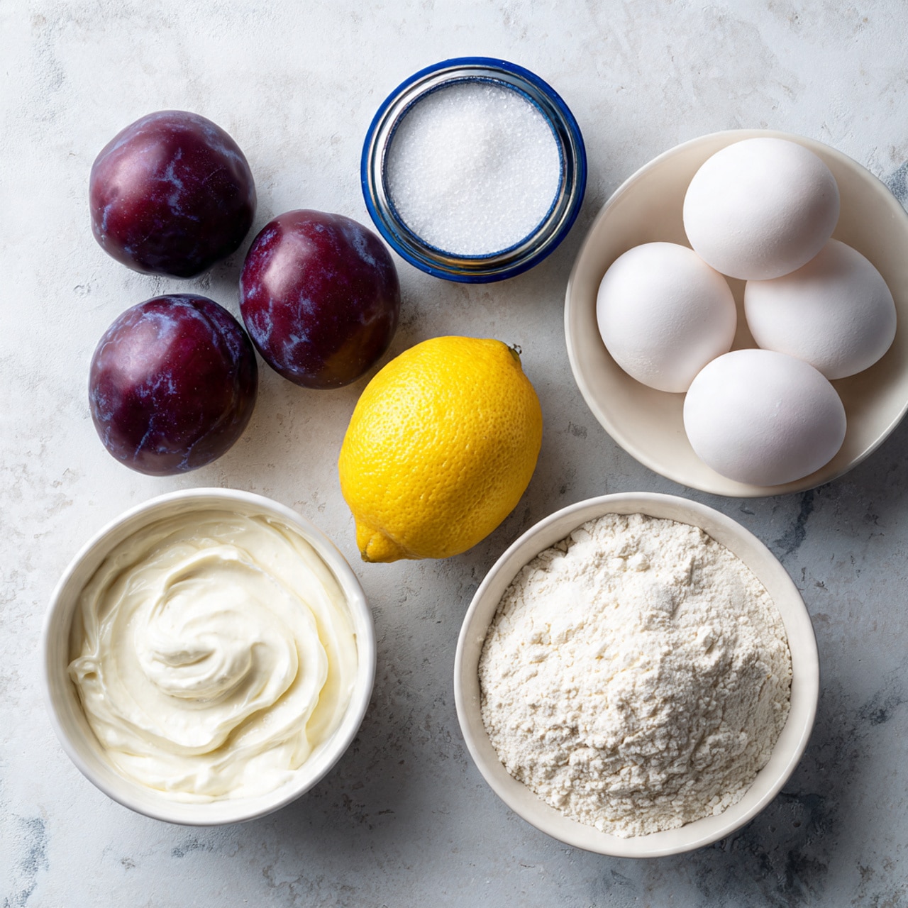 The image shows six purple plums with smooth shiny skins on a white marbled surface. To the right, there is a white bowl with five white eggs and next to it, a white container of baking powder with a blue lid. Below the plums, there is a small white bowl of thick white cream. In the center, there is one bright yellow lemon. Below the lemon, a small white bowl full of white granulated sugar and to its right, a white bowl filled with white flour. All items are placed on a white marbled texture. photo taken with an iphone --ar 4:5 --v 7