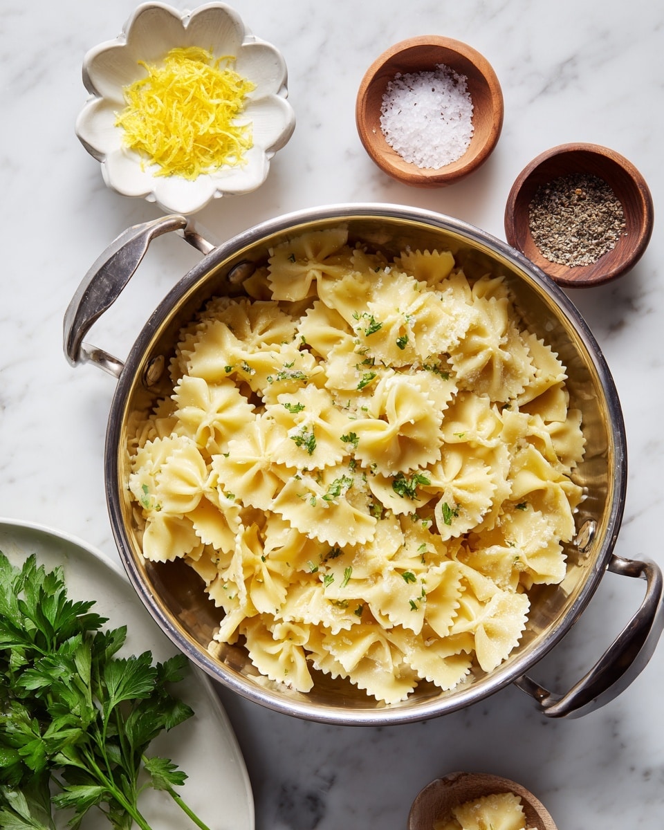 A large silver metal colander holds one layer of cooked, square-shaped pasta pieces with ruffled edges, soft yellow in color, with light steam rising from them. Above to the left, there is a small white flower-shaped dish with bright yellow lemon zest, and just above it, a small round wooden bowl contains coarse white salt and cracked black pepper. Below and to the left, a white plate holds fresh green parsley leaves. Everything is placed on a white marbled surface. photo taken with an iphone --ar 4:5 --v 7
