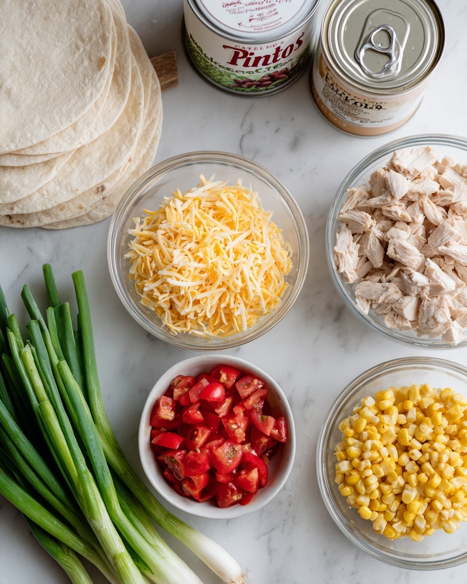 The image shows several clear and white bowls arranged on a white marbled surface. One clear bowl holds shredded yellow cheese, another clear bowl has diced cooked chicken, and a third clear bowl contains cut corn. A small white bowl filled with chopped red tomatoes is placed near the front. To the left, there are several stacked white tortillas lying flat. A group of fresh green onions with white ends points to the left foreground. In the middle back, there is a white can labeled