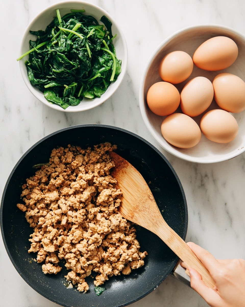 The image shows a white marbled surface with three main objects placed on top. At the bottom center, there is a black frying pan filled with cooked ground meat that is golden brown and crumbly in texture, being stirred by a wooden spatula held by a woman's hand from the right side. At the top right, there is a white bowl holding seven smooth light brown eggs, arranged loosely together. At the top left, there is a white bowl filled with chopped dark green leafy spinach, cut into thin pieces. The overall look is clean and simple with clear colors and textures. photo taken with an iphone --ar 4:5 --v 7