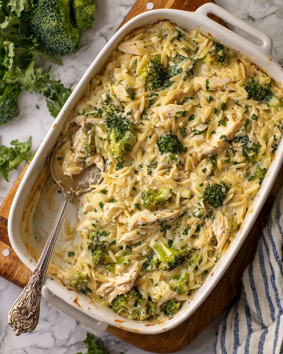 A dark grey bowl filled with a creamy pasta dish having three main layers: the bottom layer is small pasta pieces mixed with shredded white chicken, the middle layer contains cooked broccoli florets with deep green tops and light green stems, and the top layer includes creamy white sauce coating the pasta and chicken mixed with wilted spinach and chopped fresh green herbs sprinkled on top. A silver fork is placed inside the bowl and some dish elements slightly spill over the bowl’s edge onto a white marbled surface. Photo taken with an iphone --ar 4:5 --v 7