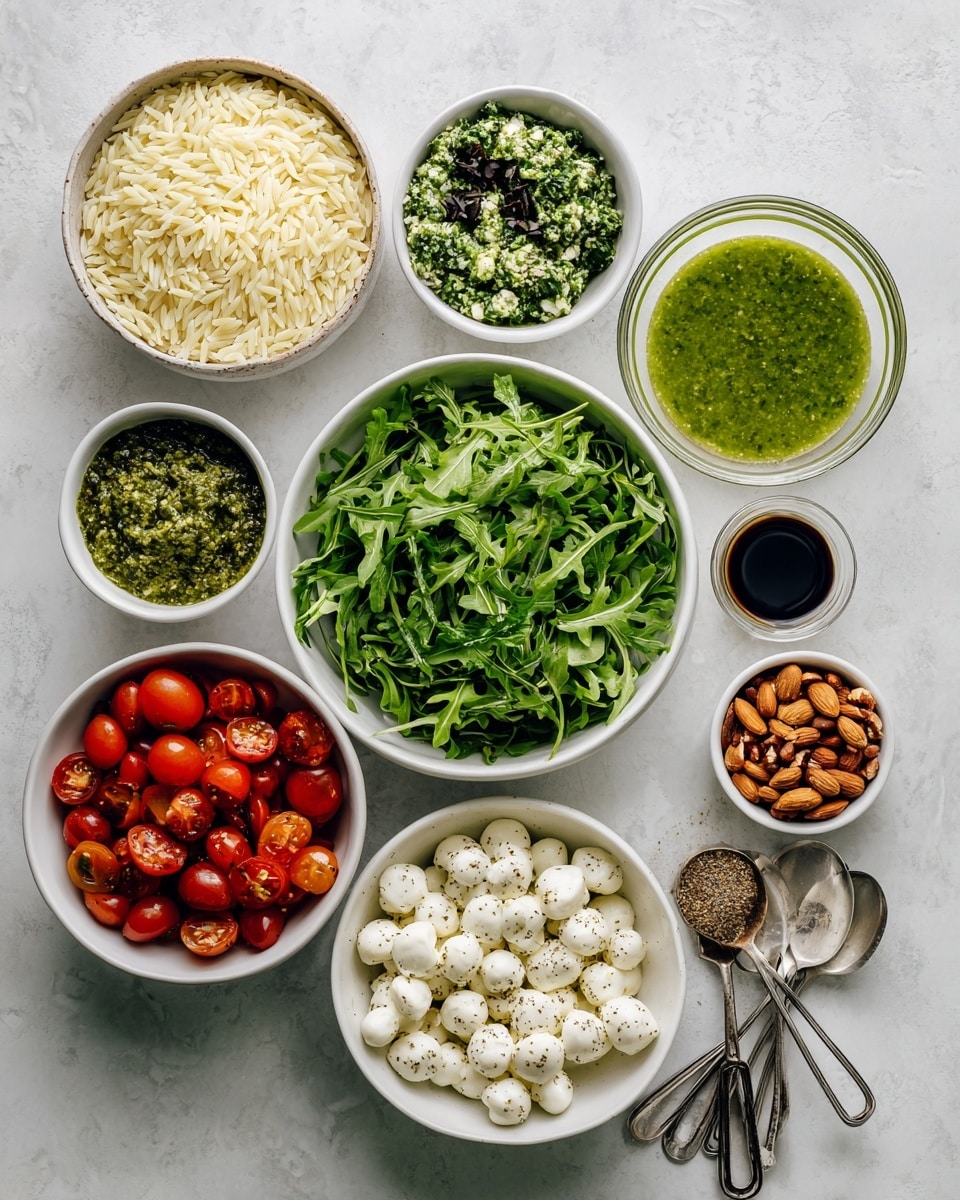 A white plate holds a layered salad starting with a base of pale yellow orzo pasta spread evenly across the plate. On top, fresh green arugula leaves are scattered, along with sliced red cherry tomatoes and pale almond slices. The dish is drizzled with dark balsamic glaze and sprinkled with coarse black pepper, adding texture and contrast. The background is a white marbled surface with some scattered arugula leaves around the plate. photo taken with an iphone --ar 4:5 --v 7