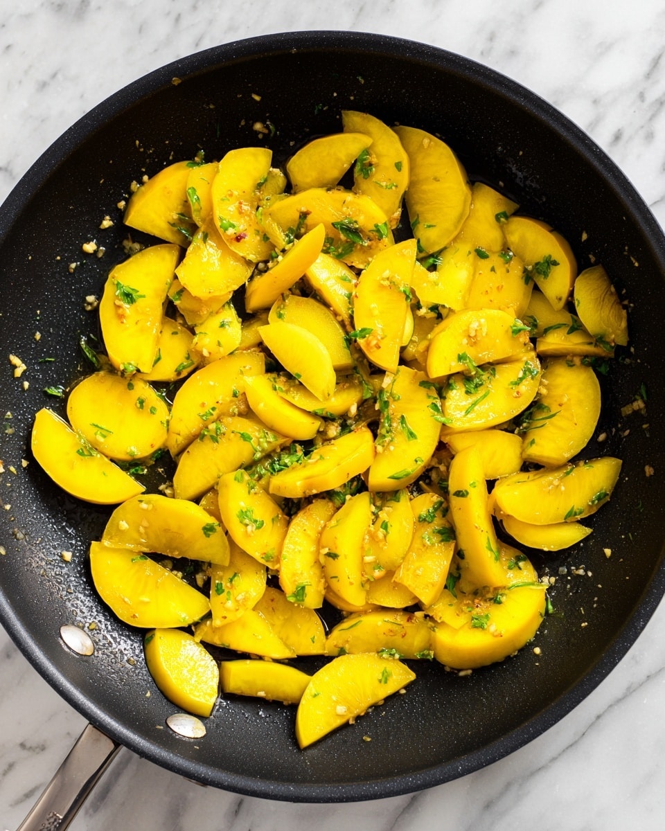 The image shows a close-up of a black frying pan filled with yellow squash pieces. The squash is cut into half-moon shapes and small sticks, spread evenly across the pan. The squash looks fresh and slightly cooked, with some pieces glistening from oil or butter. Small bits of minced garlic and herbs are sprinkled evenly among the squash. The pan is set on a white marbled surface. photo taken with an iphone --ar 4:5 --v 7