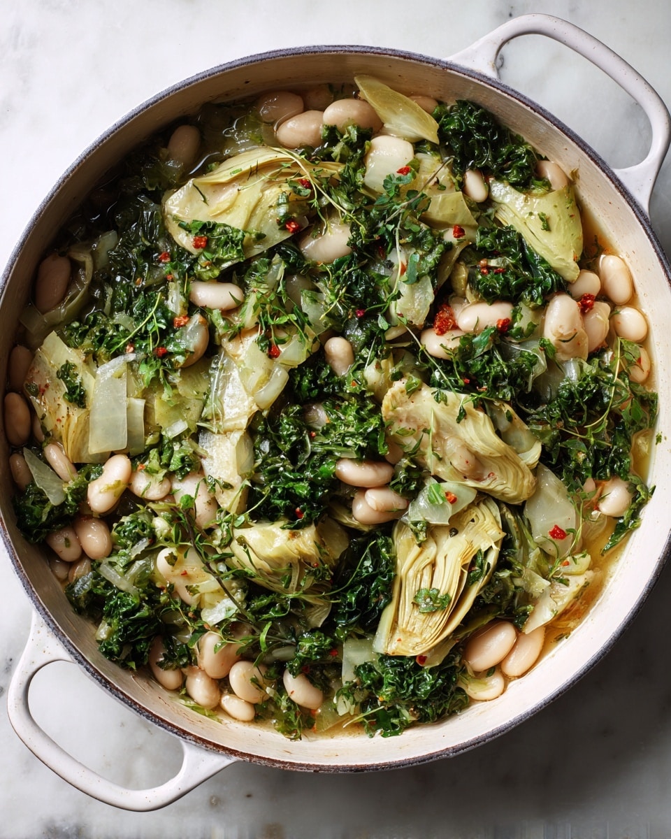 A large white pan with two handles holds a mixture of several layers. The bottom layer has soft white beans scattered throughout, mixed with light green artichoke pieces. Dark green chopped leafy vegetables and herbs cover the beans and artichokes, adding texture and color. The dish looks moist with a light broth or sauce coating the ingredients. It sits on a white marbled surface. photo taken with an iphone --ar 4:5 --v 7