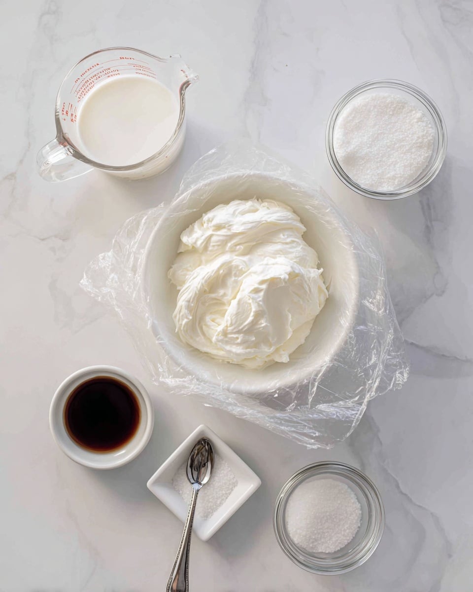 A white bowl lined with clear plastic wrap sits in the center on a white marbled surface. Surrounding it are five small containers arranged loosely in a circle: a glass measuring cup filled with white cream at the top left, a small white square dish holding a small amount of white salt nearby, a small white square dish with a silver spoon holding dark brown vanilla extract at the bottom left, a glass jar with a white measuring spoon filled with white sugar at the top right, and another glass measuring cup containing cream at the bottom right. The scene is bright and clean with soft natural light. Photo taken with an iphone --ar 4:5 --v 7