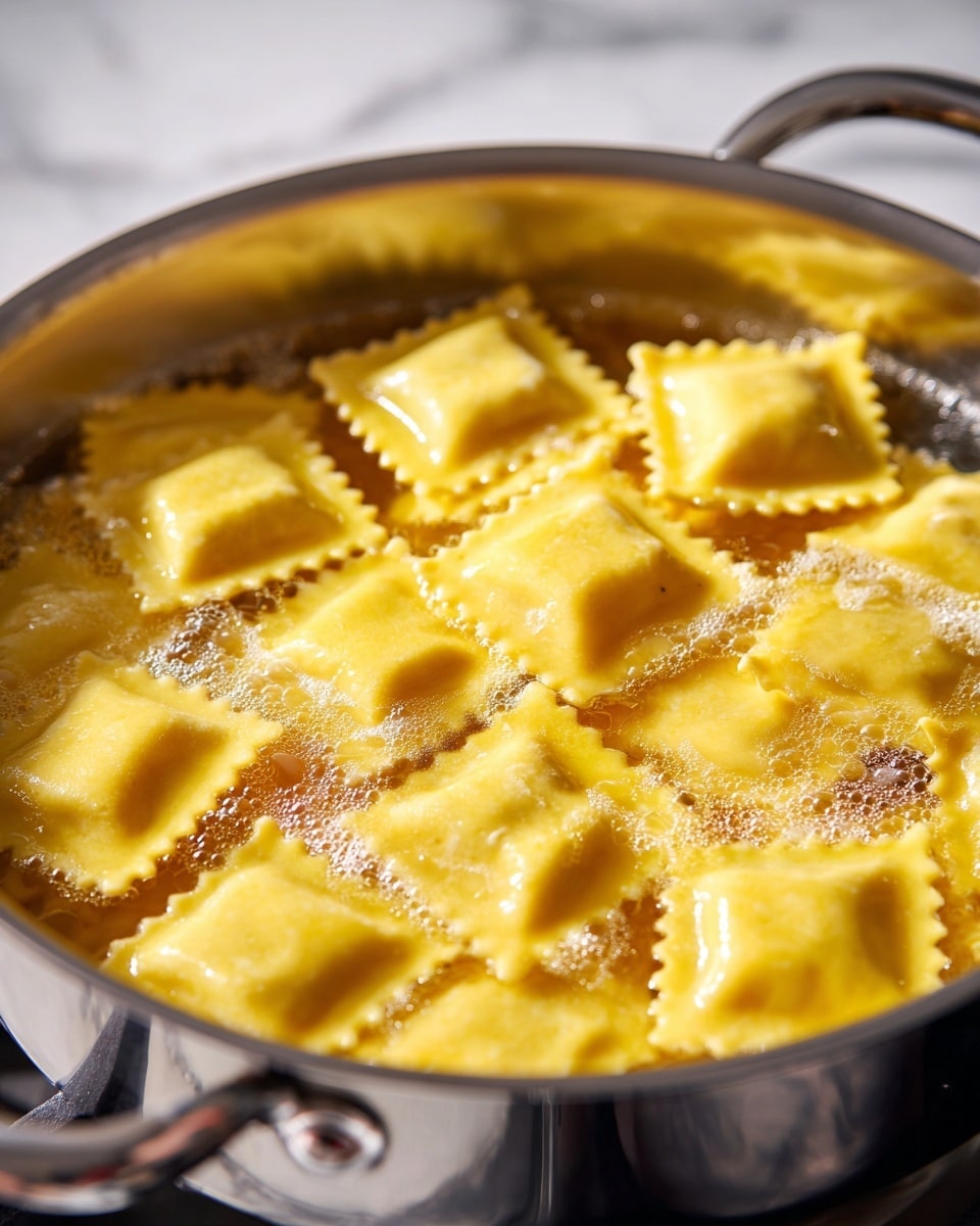 A close-up view of many yellow ravioli pieces cooking in a silver pot filled with bubbling water. The ravioli have a square shape with wavy edges and a soft, smooth texture. The pot is placed on a stove burner, and the ravioli float gently in the water, some overlapping each other in layers. The background is not fully visible but has a white marbled texture. photo taken with an iphone --ar 4:5 --v 7