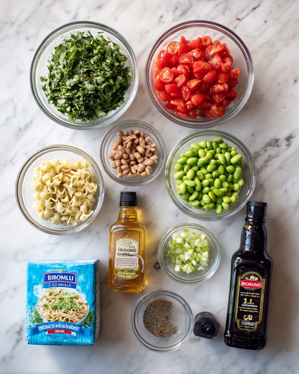This image shows cooking ingredients arranged neatly on a white marbled surface. There are four glass bowls: one with chopped green leafy herbs, one with diced red tomatoes, one with green edamame beans labeled