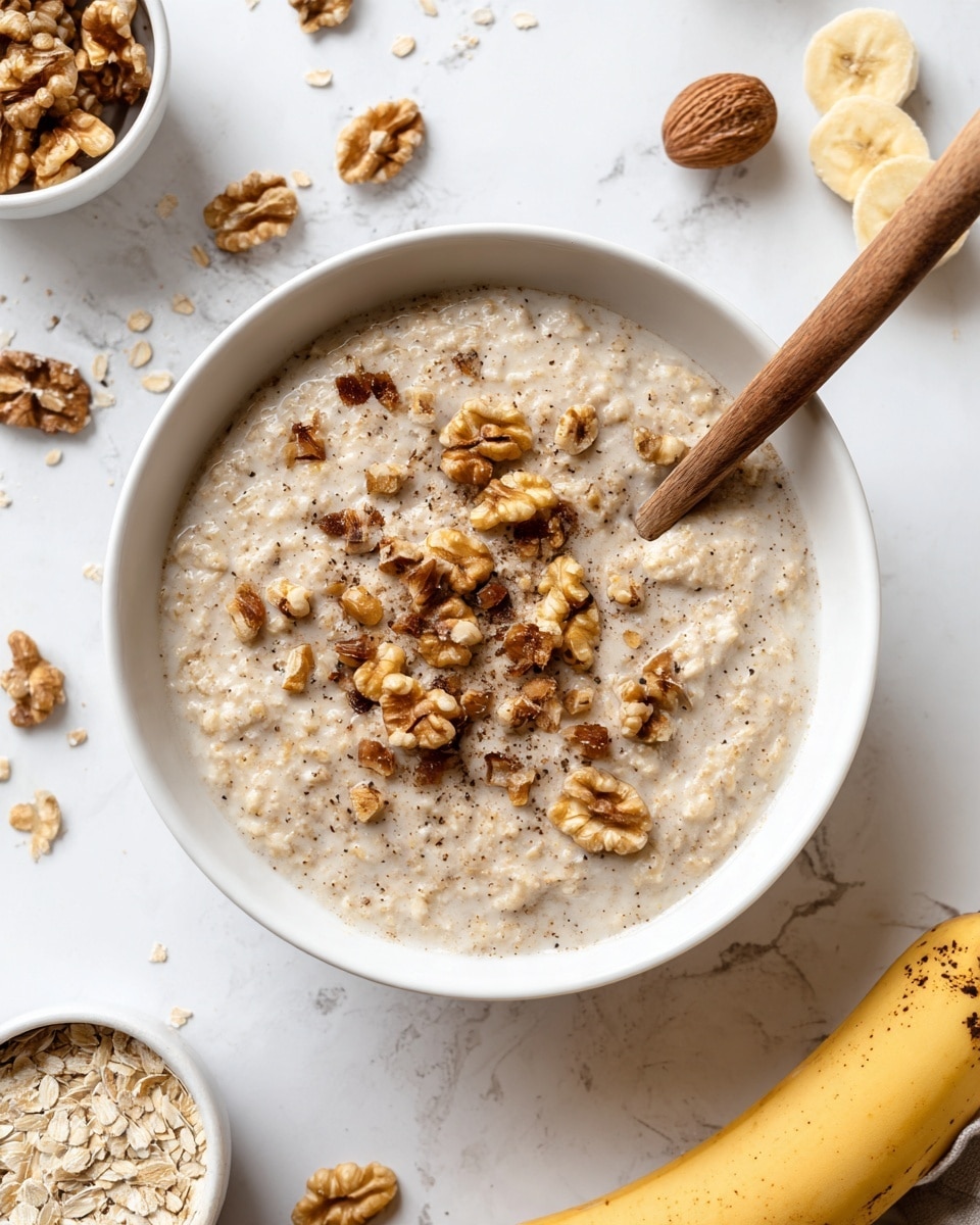 A white bowl filled with thick oatmeal, light beige in color with small visible oats and sprinkled with medium brown chopped walnuts all over the top. A wooden spoon with a light handle and dark tip rests inside the bowl on the right side. Around the bowl on a white marbled surface, scattered walnut halves, a whole ripe banana with brown spots is visible on the bottom right, and two smaller white bowls. One bowl at the top left has large brown eggshell pieces, and the other at the bottom left contains chopped walnuts and oats. Photo taken with an iphone --ar 4:5 --v 7