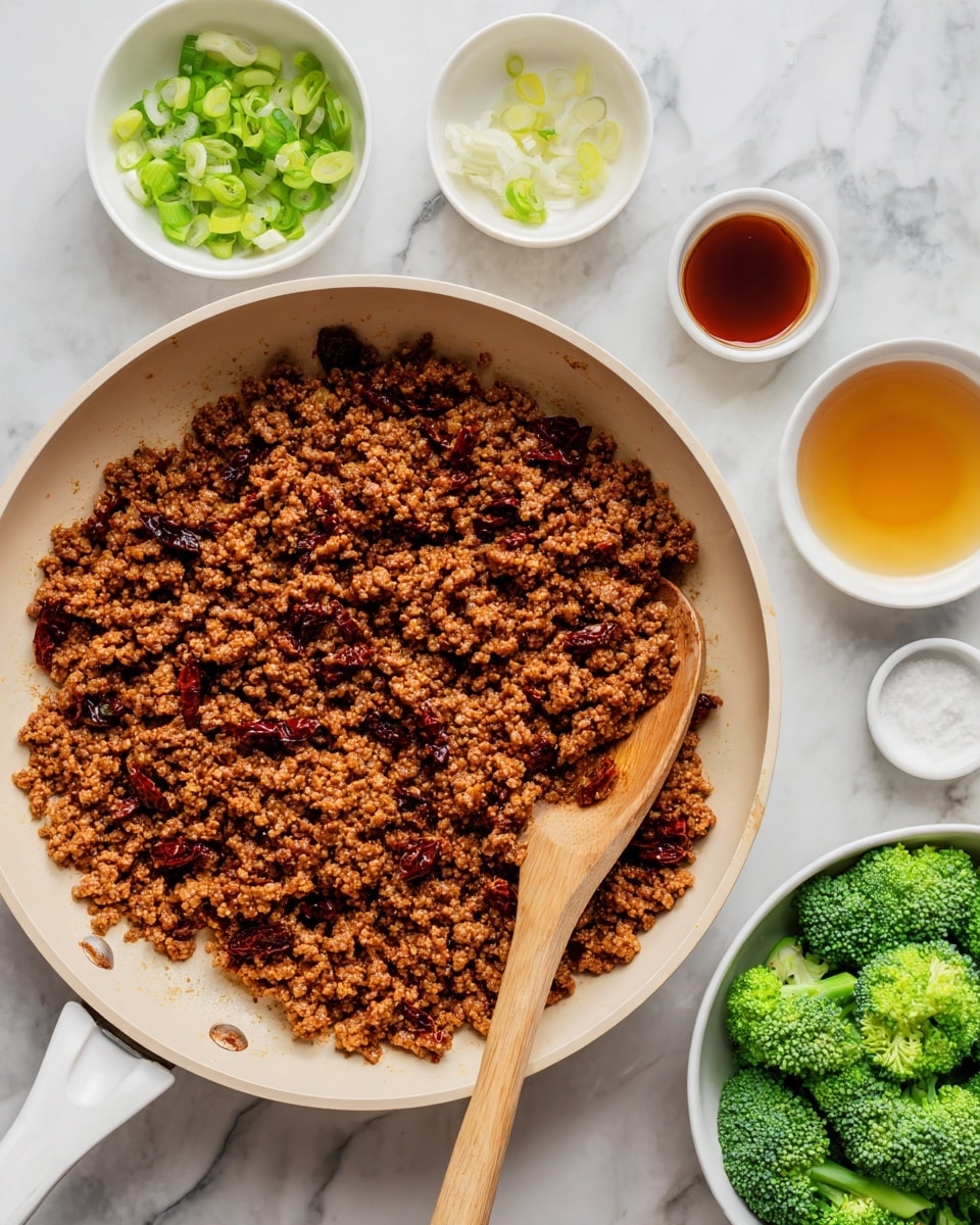 The image shows a white frying pan filled with cooked ground meat mixed with small pieces of a darker ingredient, possibly sun-dried tomatoes, creating a mix of brown and reddish-brown colors with a slightly crumbly texture. A wooden spoon rests on the right side inside the pan. Around the pan are several small white bowls containing light-colored ingredients like sliced green onions, a small amount of liquid in amber and dark brown colors, and a less defined white ingredient. At the bottom right, there is a white bowl filled with fresh green broccoli pieces, all placed on a white marbled surface. Photo taken with an iphone --ar 4:5 --v 7
